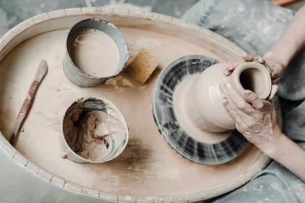 Photo d'en haut. Les mains des filles font un vase d'argile sur une roue de potiers. Fabrication de poterie — Photo