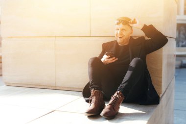  Programcı, ofisten iyi haberler almış ve sokakta mutlu. Elinde bir telefon tutuyordu. İş fikri