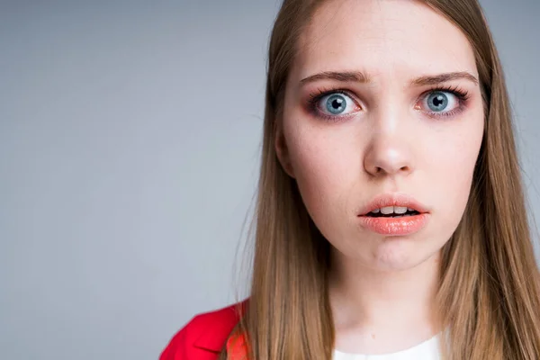 Feche a foto. Menina bonita bonita com cabelo loiro olhando tristemente para a câmera abrindo a boca — Fotografia de Stock