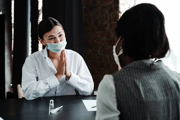 Азиатка-врач в медицинской маске умоляет африканскую американку сделать вакцину против вируса — стоковое фото