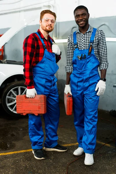 Červenovlasí a afro-američtí mechanici s kufříky s přístroji jsou připraveni opravit auta — Stock fotografie