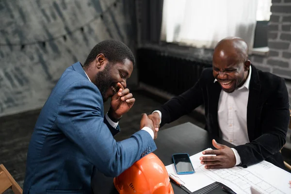 Δύο Αφροαμερικανοί υπέγραψαν μια συμφωνία και κάνουν χειραψία. Επιχειρηματίες κάθονται σε ένα τραπέζι γραφείου — Φωτογραφία Αρχείου