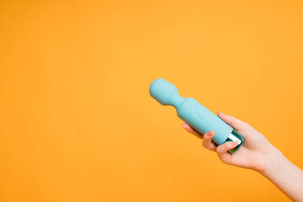 Blue vibrator or masturbation massager on an orange background. Flat Lay. Sex shop concept