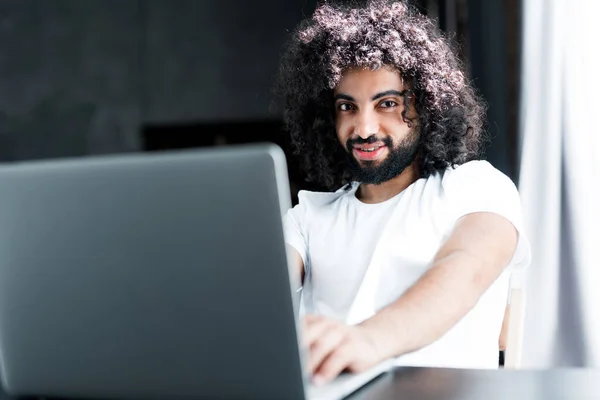 Glücklicher afroamerikanischer Student in weißem T-Shirt, der mit einem Tutor am Laptop lernt Stockbild