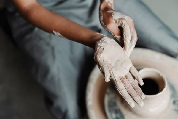 女性手握粘土，在陶器作坊里画着一颗心。广告概念 免版税图库照片