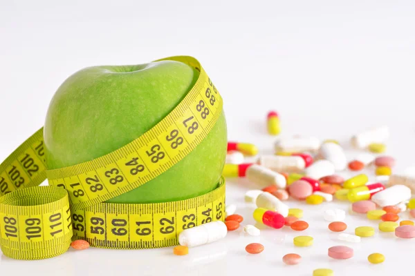 Ernährungskonzept - grüne Äpfel, Pillen und Maßband — Stockfoto
