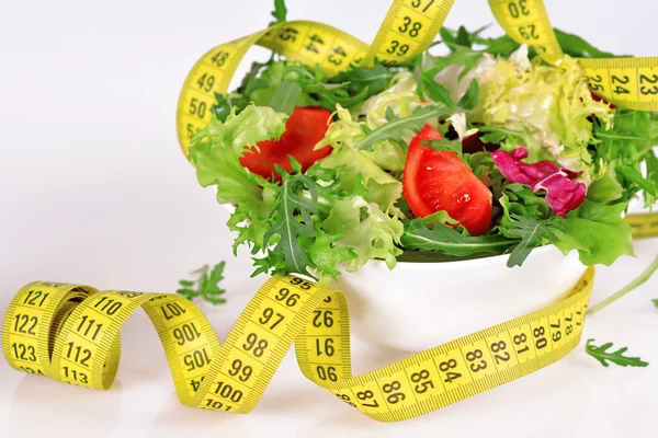 Ernährungskonzept - Salat und Maßband — Stockfoto