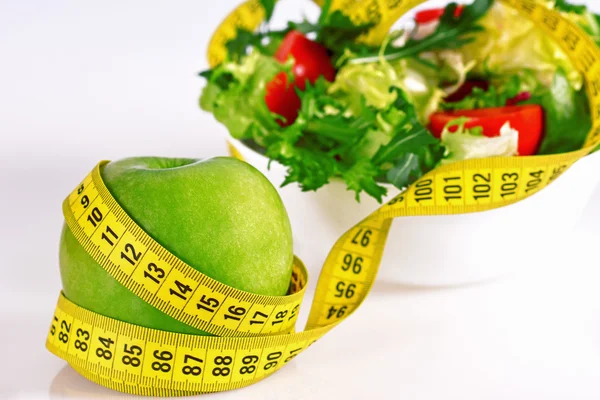 Ernährungskonzept - grüne Äpfel, Salat, Pillen und Maßband — Stockfoto