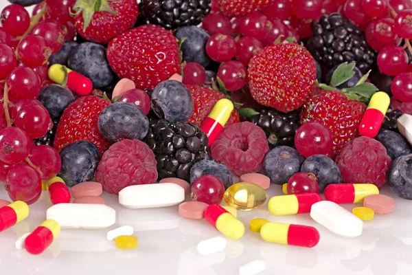 Berries, vitamins and nutritional supplements — Stock Photo, Image