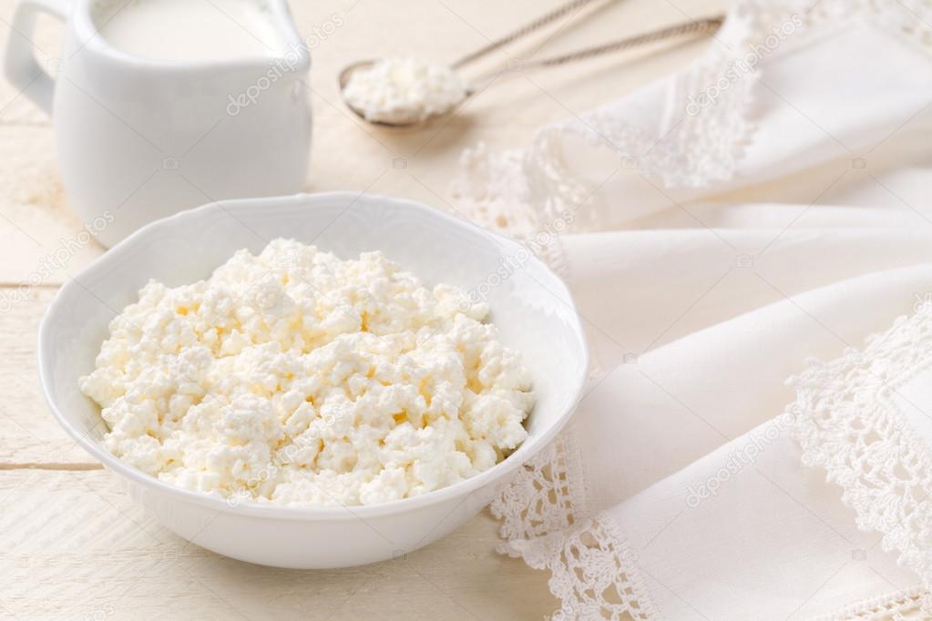 Fresh cottage cheese on a white wooden table (closeup)