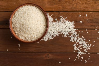 Beyaz ahşap bir masa üzerinde kahverengi bir seramik kase pirinç