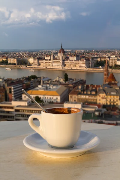 Tasse Kaffee mit Blick auf das Parlamentsgebäude in Budapest lizenzfreie Stockfotos
