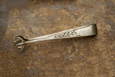 Eski bir metal arka plan üzerinde Vintage şeker maşası