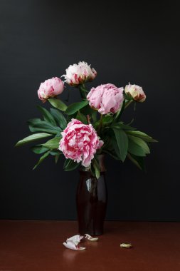 Karanlık bir arka plan üzerinde vazoda Peonies