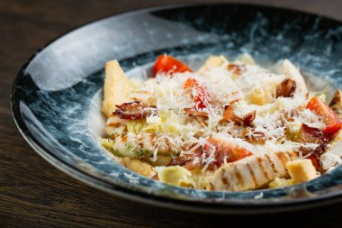 Izgara tavuk göğsü ile Sezar salatası. Taze sebzeli Yunan salatası, kızarmış ekmek, kızarmış domuz pastırması, bıldırcın yumurtası ve rendelenmiş peynir.