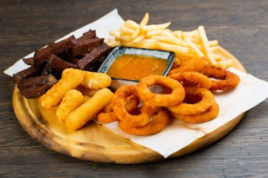 Kızarmış patates, patates, nugget ve hardal soslu soğan halkaları. Bira abur cuburdur. bar menüsü