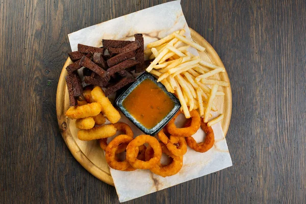 Kızarmış patates, patates, nugget ve hardal soslu soğan halkaları. Bira abur cuburdur. bar menüsü