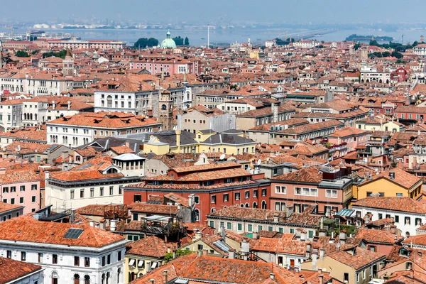 Scenic top view of the old city of Venice, tiled roofs of houses, palaces and cathedrals and the Venetian lagoon