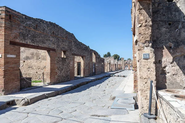 紀元79年のヴェスヴィオ山の噴火で破壊されたポンペイの古代都市の典型的な通り 家の遺跡や通りの大きな石で舗装された 明るい晴れた日 — ストック写真