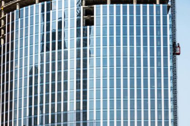 Moskova, Rusya - 13 Nisan 2021: Ayna yüzeyinde yansımaları olan modern bir gökdelenin yakın çekim parçası.