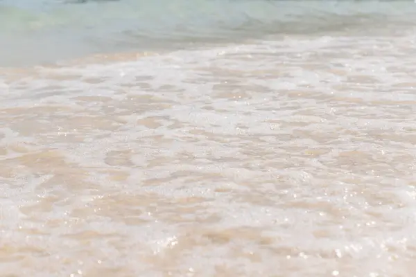 海水面上の柔らかい白い泡波が近くの砂の上にリップル — ストック写真