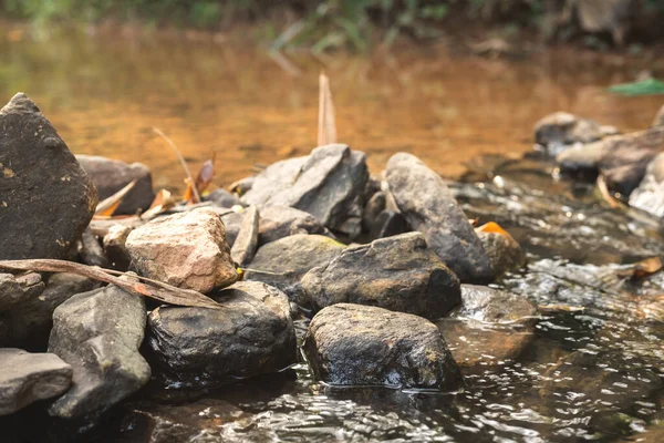 水の蒸気が流れる川で堰を作るために使用される石の近くに — ストック写真