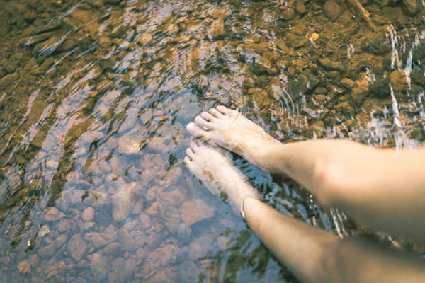 記憶の中では女性は足を水に入れて川の下に石を置き — ストック写真