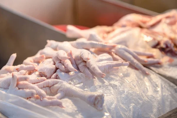 close up Chicken feet on ice to freeze for sell at market with chicken organ beside