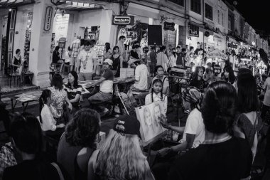 Phuket, Tayland - 05 Kasım 2017: LardYai, Phuket 'teki eski kasaba yolunun büyük gece pazarı, birkaç kişi yürüyor ve bazı gerçekçi insan resimleri çiziyor.