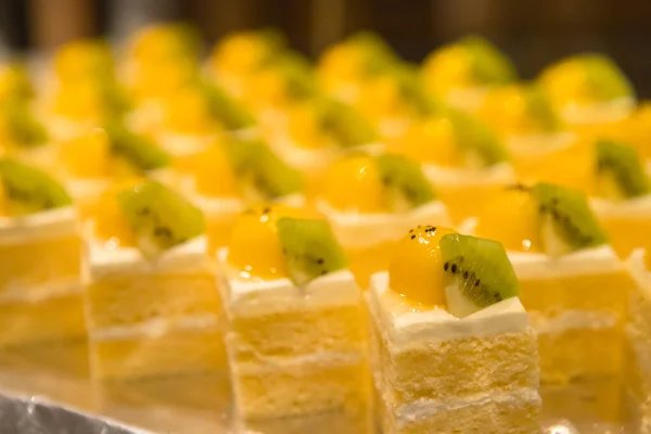 closeup of cream cake with fruits on topping for party buffet in hotel hall