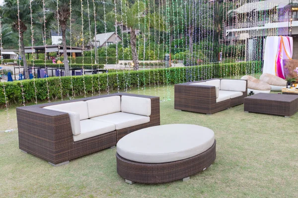 sofa set put on grass at outdoor party with led light decorate behind