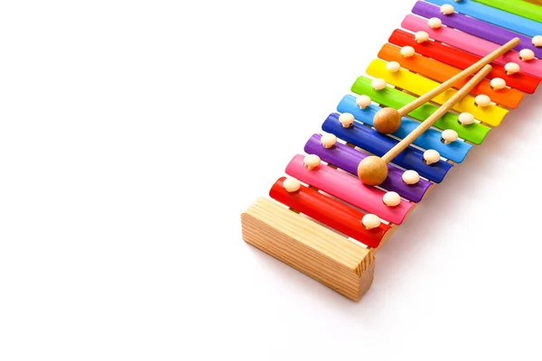 彩虹色玩具木琴，白色背景上有两根木棍。复制空间 — 图库照片