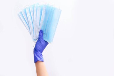 Mavi eldivenli doktor, beyaz arka planda salgın hastalıklar, salgın hastalıklar, Covid19 konsepti için antivirüs maskeleri tutuyor.