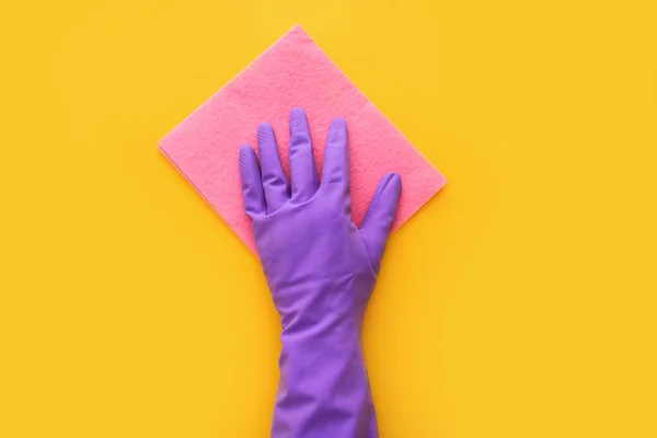 Employee hand in rubber protective glove with micro fiber cloth on yellow background. Spring general or regular clean up. Top view — Stock Photo, Image