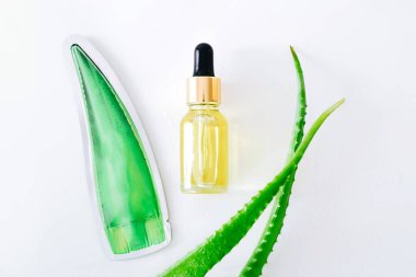 Aloe vera leaves and glass jar with cosmetics product with aloe vera essence on white background. Top view