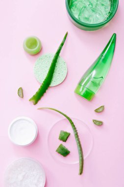 Aloe Vera kozmetik ürünleri. Pembe arka planda doğal bitkisel cilt ürünleri. Üst görünüm