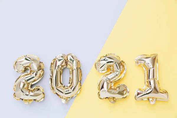 Balony foliowe w postaci numerów 2021 na szarym i żółtym tle. Święto Nowego Roku. — Zdjęcie stockowe