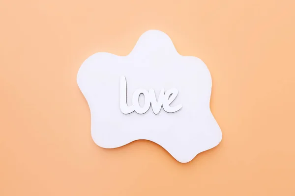 Деревянное слово Love on white concrete geometric shape on orange background, top view — стоковое фото