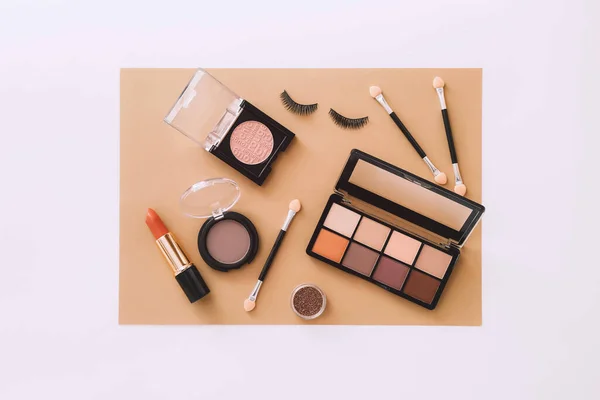 Makeup products on beige and white background. Top view — Stock Photo, Image