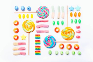 Beyaz arka planda renkli şekerlerden oluşan karışık bir koleksiyon. Düz yatış, üst görünüm