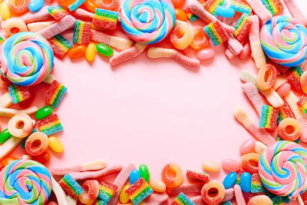 Keret vegyes gyűjtemény színes cukorka, rózsaszín háttérrel. Lapos fekvésű, felülnézet — Stock Fotó