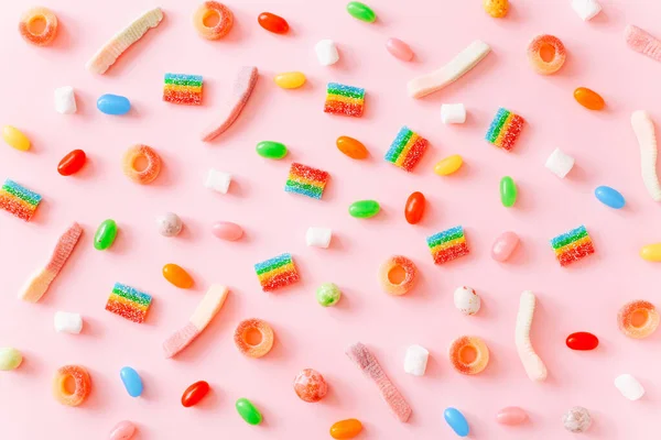 Regenbogen saftige Gummibärchen Hintergrund. Muster aus Gelee-Bonbons auf rosa Hintergrund — Stockfoto