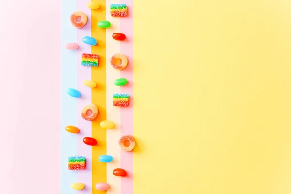 Rainbow bonbons gommeux juteux fond. Modèle de bonbons gelée sur fond coloré. Vue du dessus — Photo