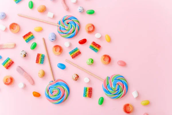 Vegyes gyűjtemény színes cukorka, rózsaszín háttérrel. Lapos fekvésű, felülnézet — Stock Fotó