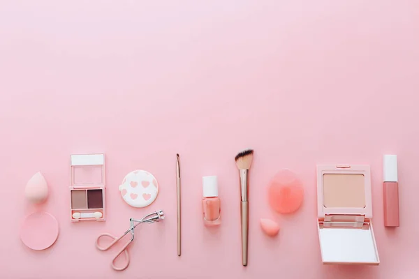 Набор декоративной косметики на розовом фоне — стоковое фото