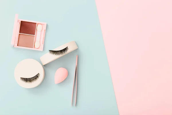 Composición plana con productos para maquillaje decorativo sobre fondo azul pastel y rosa — Foto de Stock