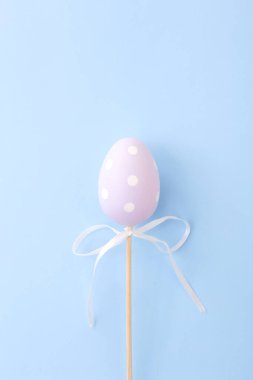 Mavi arka planda leylak rengi Paskalya yumurtası. Fotokopi alanı olan Paskalya Bayramı tebrik kartı.