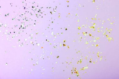 Leylak arka planında renkli konfeti. Tatil arkaplanı, üst görünüm