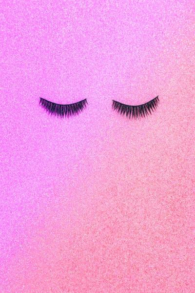 Artificial eyelashes for makeup on a shiny colorful background. The view from the top.
