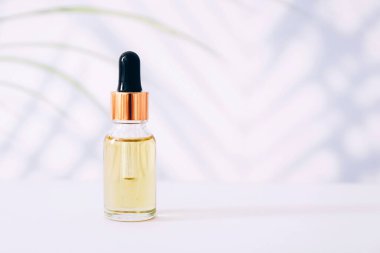 Işık arka planında serum ya da gerekli yağ şişesi. Doğal organik kozmetik